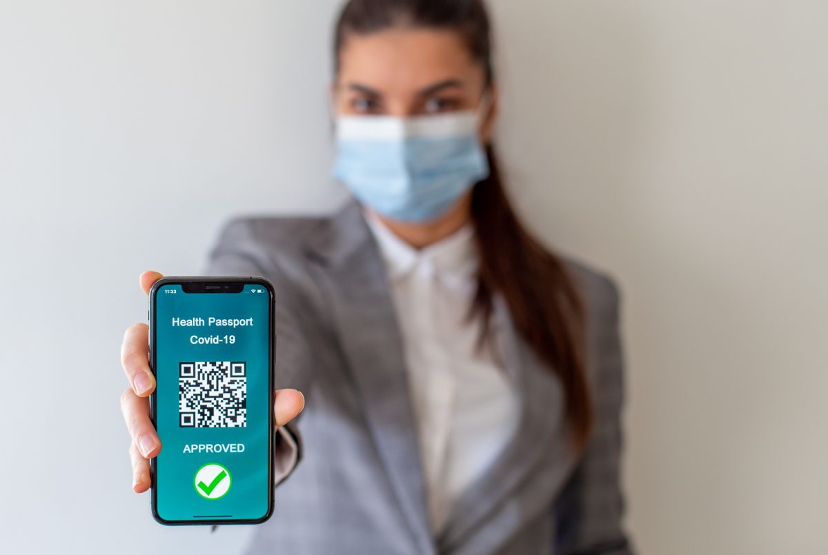 Portrait of a vaccinated person using digital health passport app in mobile phone for travel during covid-19 pandemic.